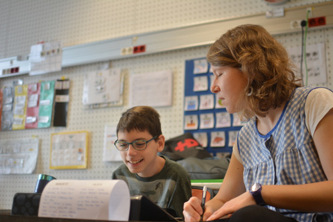 Una mestra del centre ajudant a un alumne a compondre el seu garrotin